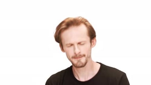 Junger gutaussehender Mann singt tanzend lächelnd auf weißem Hintergrund