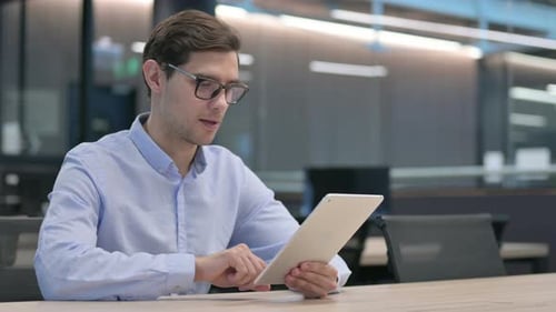 Jeune homme utilisant une tablette au travail