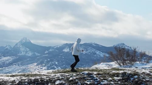 Lone Runner in Snowy Mountains
