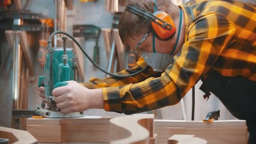 Man Works With Woodworking Tool in Workshop