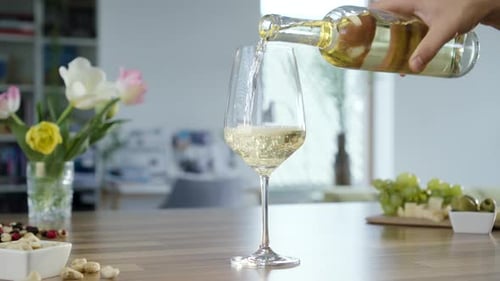 Pouring Wine in Glass with Grapes and Flowers