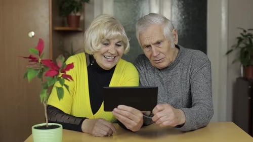 Senior Couple Using Tablet at Home Together