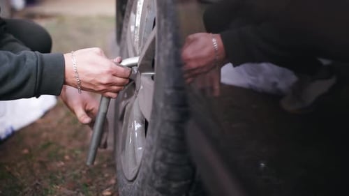 Man Changing Tire With Lug Wrench