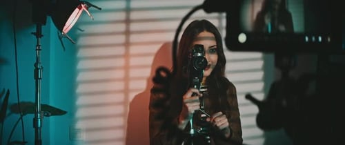 Woman Adjusting Settings on Vintage Film Camera