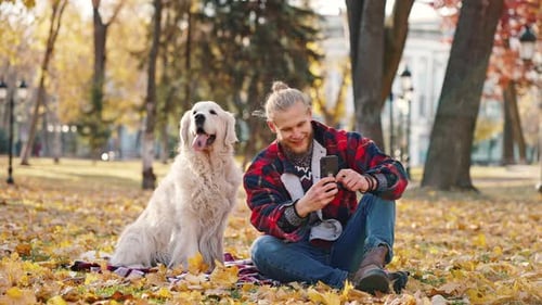 Blonde Person and Dog in the Park in Autumn
