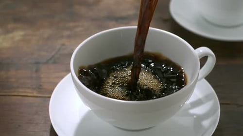 Coffee being poured into white coffee cup