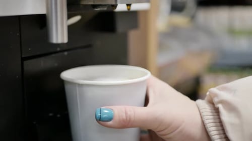 Coffee Being Dispensed from Machine into Paper Cup