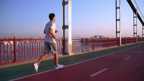 Man Is Running Along the Bridge
