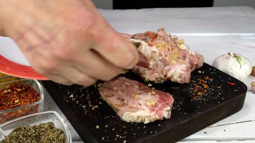Seasoning Raw Meat on a Cutting Board