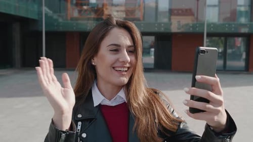 Attractive Woman Video Calling on Smartphone Outdoors
