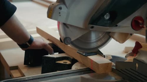 Close Up of Carpenter's Hands Cutting Wood with Table Saw in Workshop, Craftsman Furniture