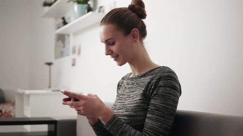 Young Woman Using Smartphone in Modern Home