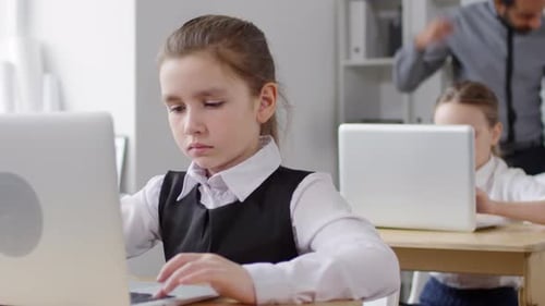 Diligent Caucasian Schoolgirl Working on Laptop at School