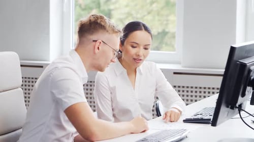 Diverse team of young professionals is working in the phone support office.