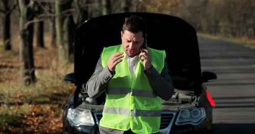 Man Talking on Cellphone with Car Trouble on Road
