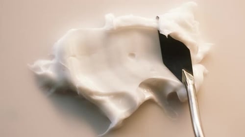 Creamy White Lotion with Metal Spatula, Close Up