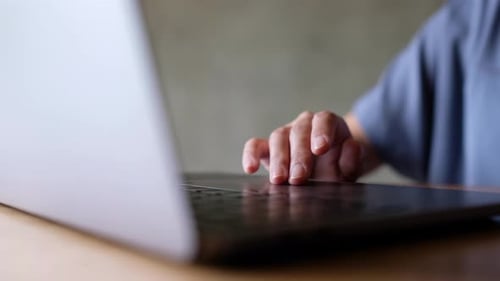 Person Using Laptop Trackpad to Scroll Up