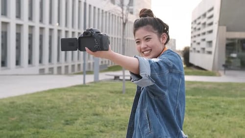 Mujer asiática que vloguea y usa la cámara, influenciadora de redes sociales, creadora de contenido