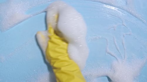 Gloved Hand Cleaning Surface with Soapy Foam