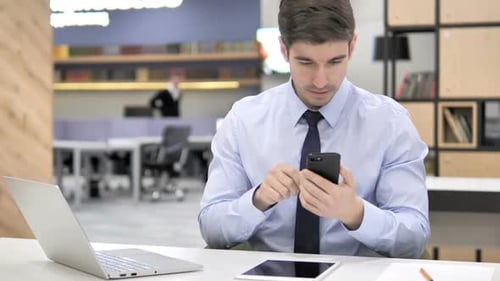 Excited Young Man Celebrating Success on Smartphone