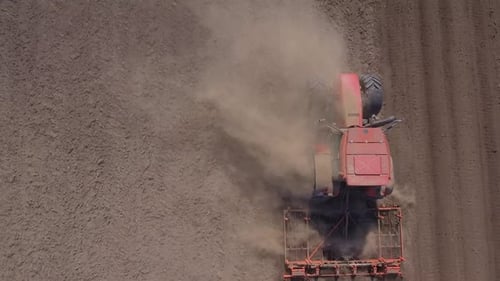 Aerial Shot of Red Tractor Plowing Dirt in Farm