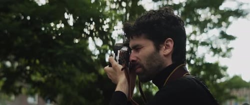 Young Adult Taking Pictures with a Film Camera