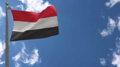 Yemen Flag Waving on Flagpole Against Blue Sky