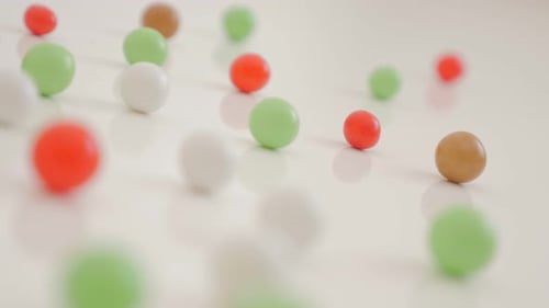 Round shaped bonbons arranged on white reflective background 4K 2160p UltraHD footage - Shiny colorf