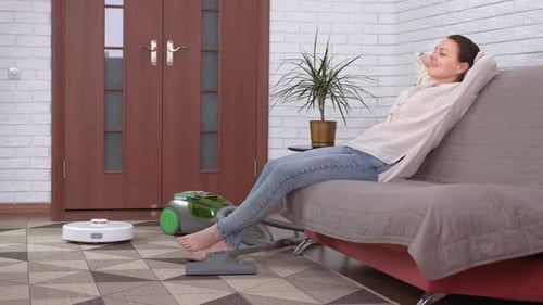 Adult Woman Relaxing While Robot Vacuum Cleans