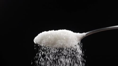 Sugar Pouring From Spoon Close Up