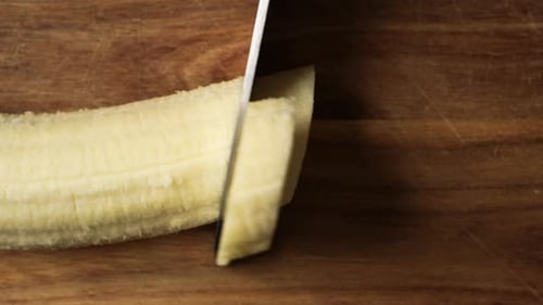 Banana Sliced on a Wooden Cutting Board