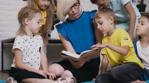 Teacher Reads to Children in Classroom Setting