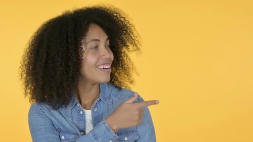Smiling Woman Points to the Right on Yellow