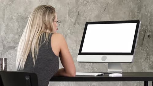 Woman Looks at Computer Monitor in Office