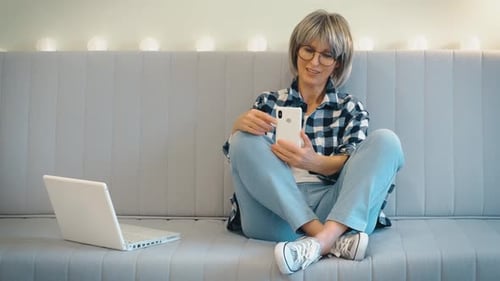Woman Waves During Video Call on Couch