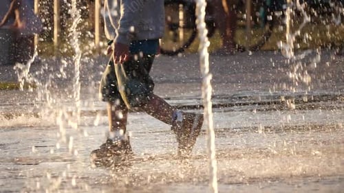 Kids playing in fountain with waterspouts coming from underneath, happy and curious