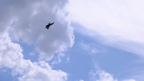 Fighter Jet Flying Against Cloudy Blue Sky