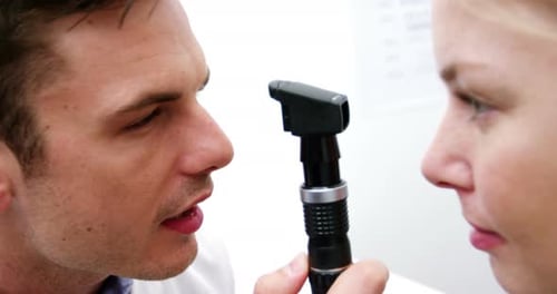 Augenarzt untersucht Patientin mit einem Ophthalmoskop