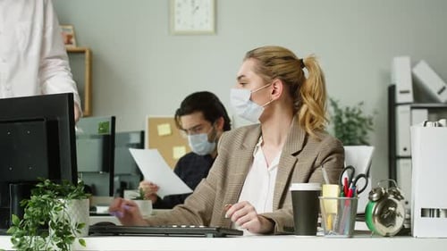 Young Blonde Woman Wearing Medical Protective Mask Working in Office Businesswoman Signing the