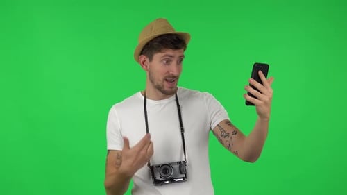 Portrait of Confident Guy Is Talking for Video Chat Using Mobile Phone. Green Screen