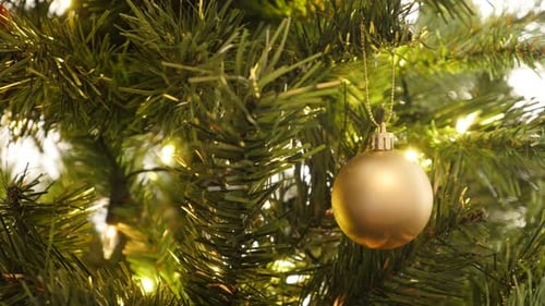 Decorative golden bauble on the artificial tree close-up 4K 2160p 30fps UltraHD footage - Christma