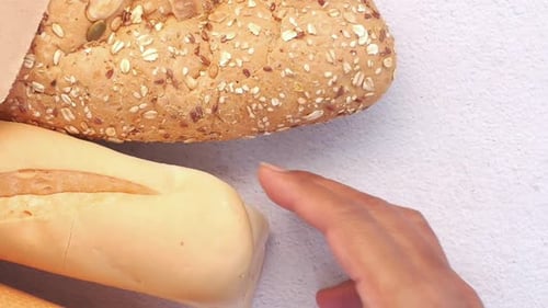 Picking Whole Grain Brown Baked Bread on Table