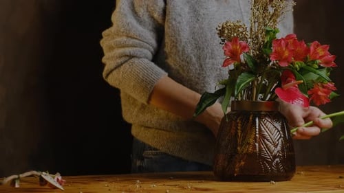 Woman Arranges Flower Bouquet in Glass Vase