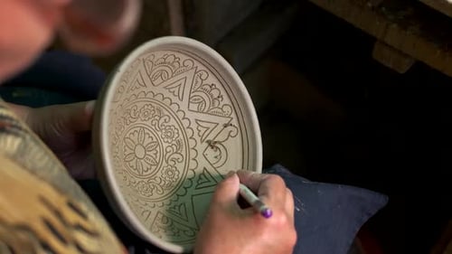 Man Painting Clay Bowl in Pottery Workshop