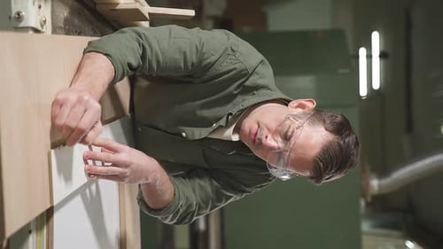 Confident Carpenter Working with Equipment on Wooden Table in Carpentry Shop
