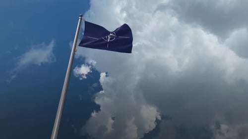 NATO Flag Waving in the Wind with Clouds