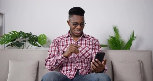 Young Man Video Calling On Smartphone At Home