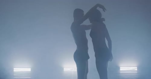Couple Preforming Art or Contemporary Dance in Room Filled with Smoke