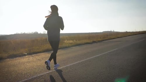 Young Fitness Sport Woman Running on Road at Sunset