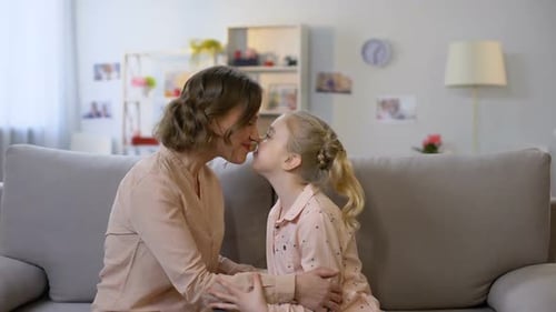 Young Mother and Daughter Nuzzling Sitting on Sofa, Close Family Relations, Love